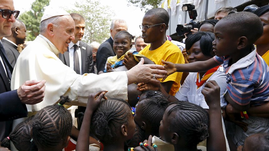 Pope Francis shakes hands with children