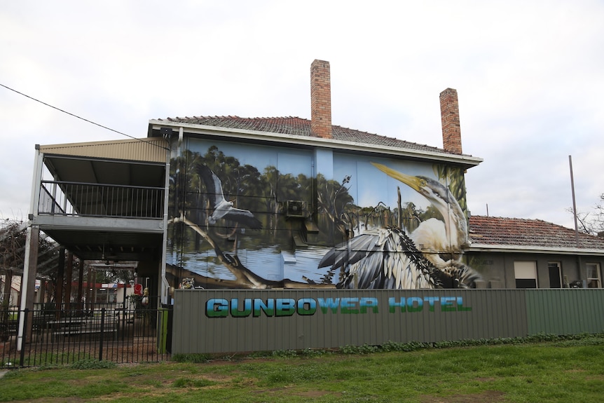 A mural is painted on the side of an old building.