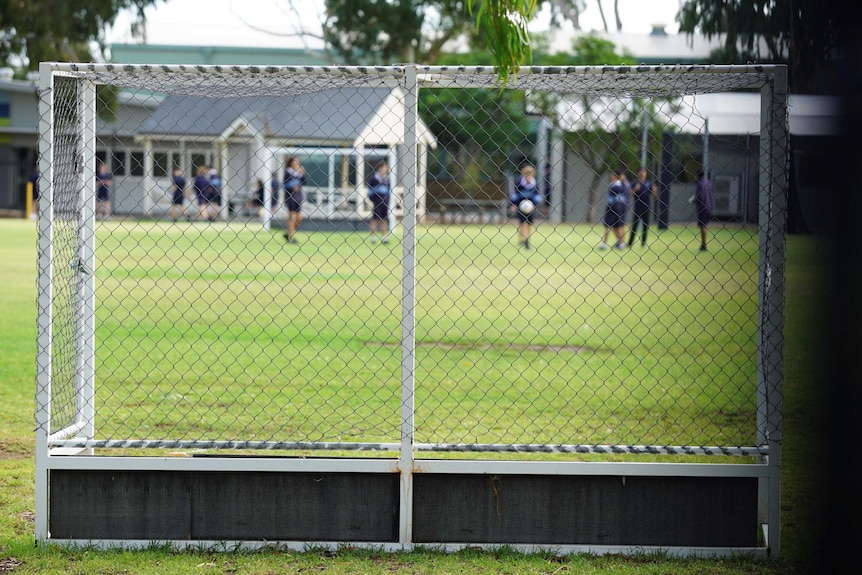 A soccer net with a playground behind it