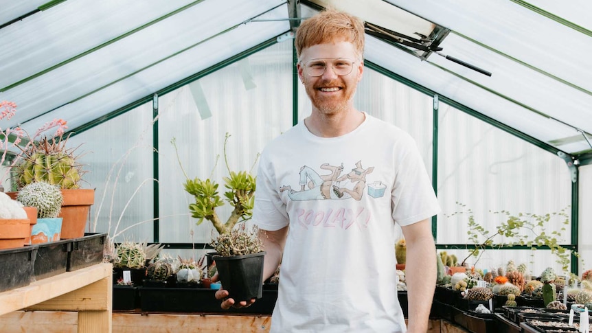 Andy Kepitis holds a succulent inside his backyard greenhouse, a horticulturalist and plant collector.