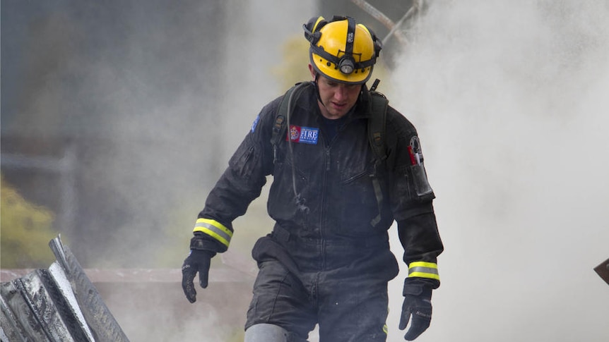 A rescue worker looks for signs of life in the rubble of the CTV building in central Christchurch after an earthquake