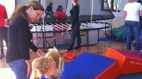Parents watch as children play inside the centre