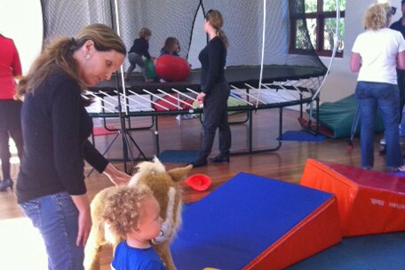 Parents watch as children play inside the centre