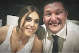 a man smiling sitting next to a woman wearing a wedding dress