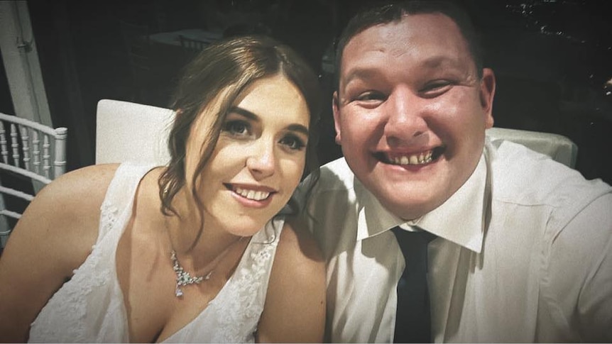 A pair of smiling newlyweds at their reception.