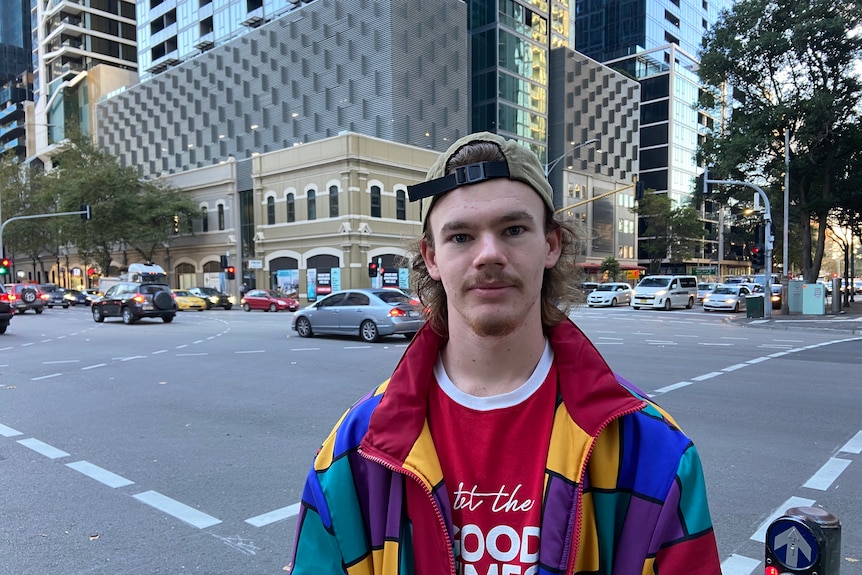 A young man standing at an intersection.