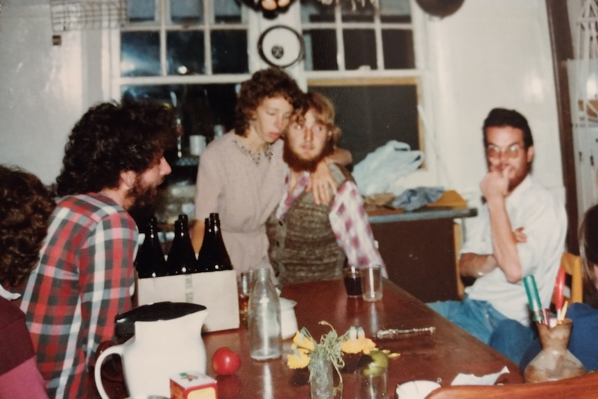 A colour photograph of men and women in the 1980s at a party