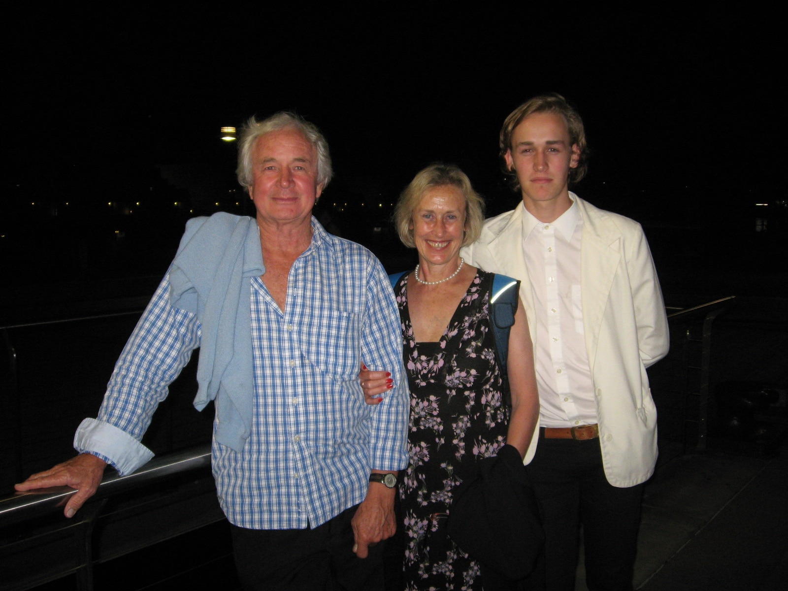 Um retrato feliz de um homem posando com uma mulher e um jovem.