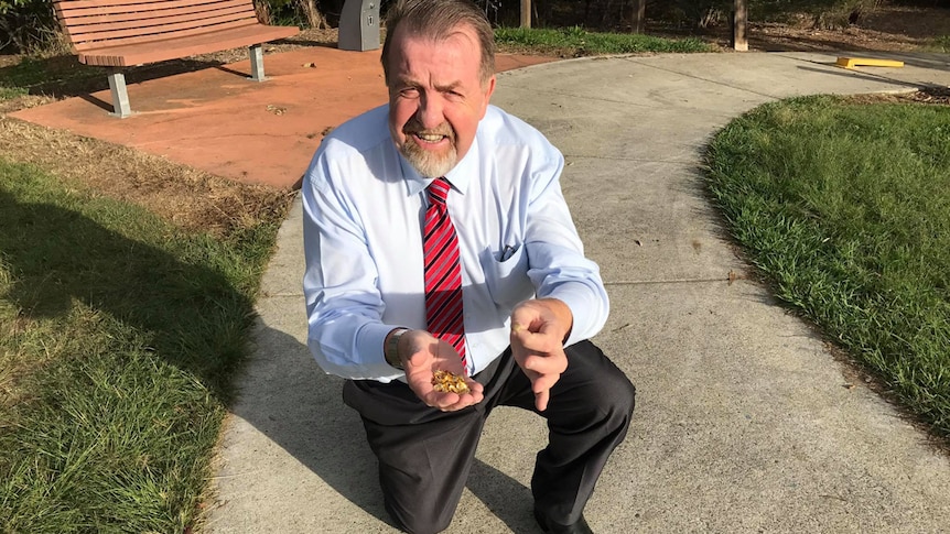 Acting Mayor Paul Tully holds thumbtacks in his hand.