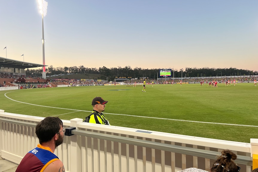 Women playing AFL at a large arena.