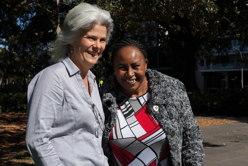 The Freedom Network's Jenny Stanger and slavery survivor Susan smiling in park.