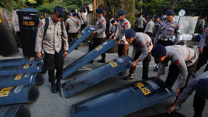 Police prepare their equipment near the court.