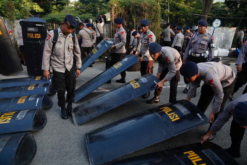 Police prepare their equipment near the court.