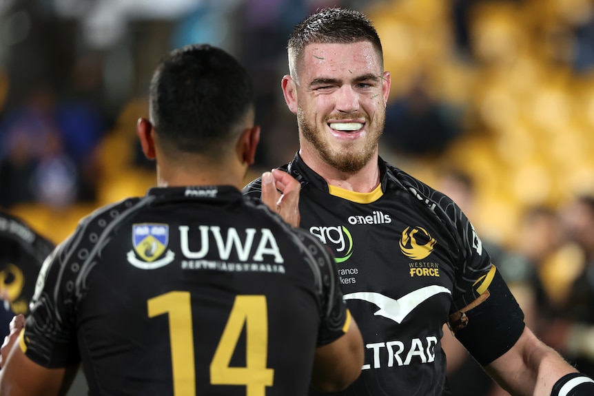 Two Western Force Super Rugby Pacific players celebrate a win.