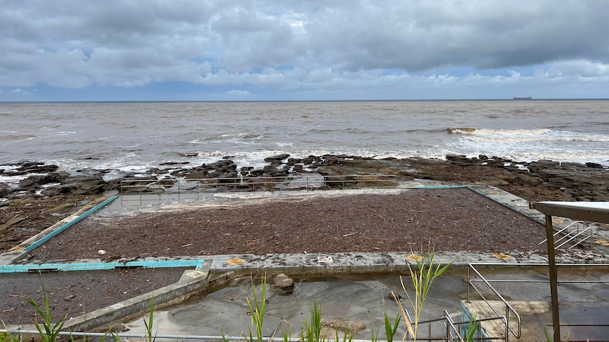 Ocean swimming pool filled with debris