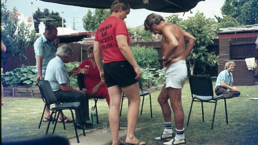 Bob Hawke wearing no shirt, chats to a union supporter at a backyard BBQ in 1980.