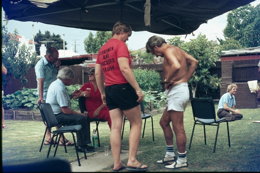 Bob Hawke wearing no shirt, chats to a union supporter at a backyard BBQ in 1980.