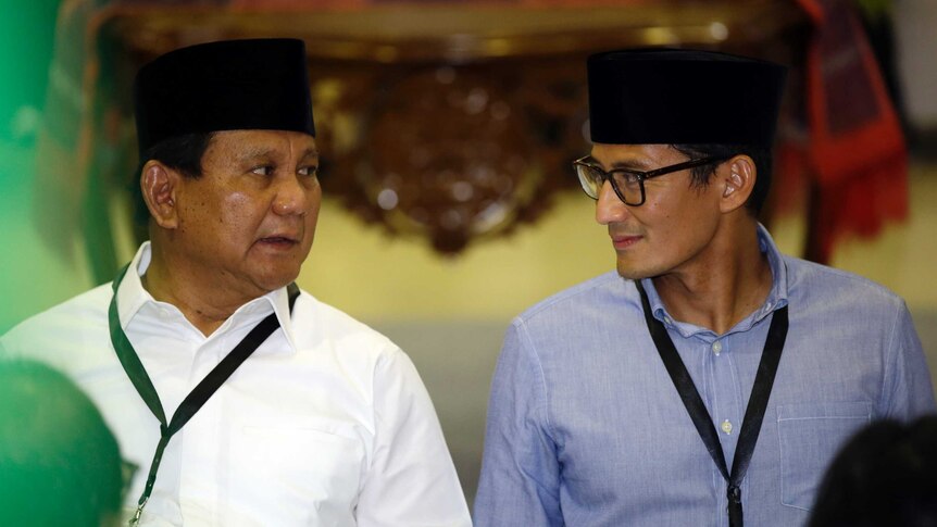 Indonesian presidential candidate Prabowo Subianto, left, talks to his running mate Sandiaga Uno during VP registrations