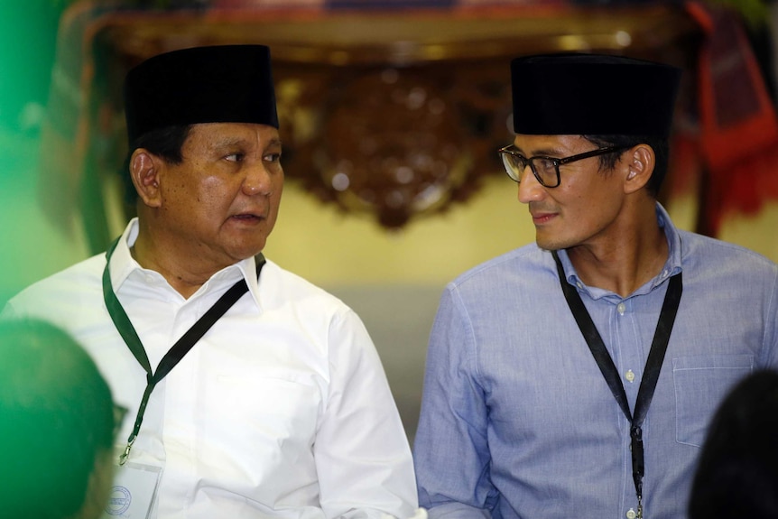 Indonesian presidential candidate Prabowo Subianto, left, talks to his running mate Sandiaga Uno during VP registrations