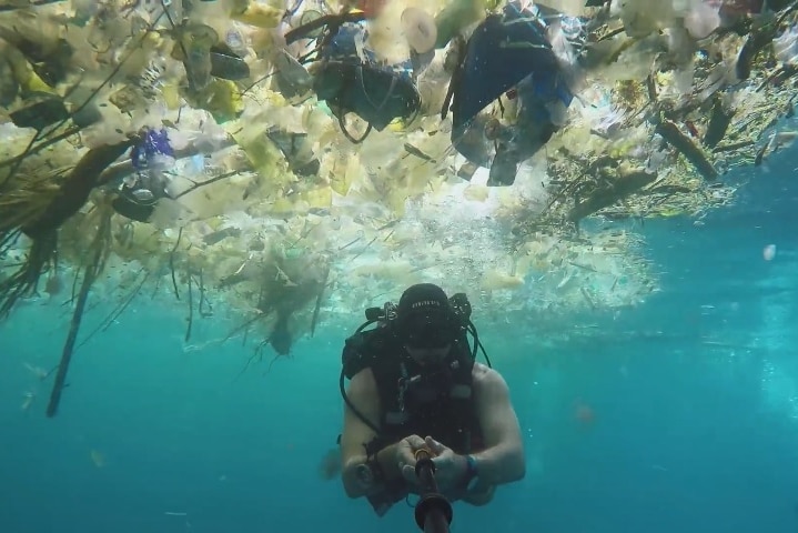 An underwater shot showing a huge amount of rubbish in the sea.