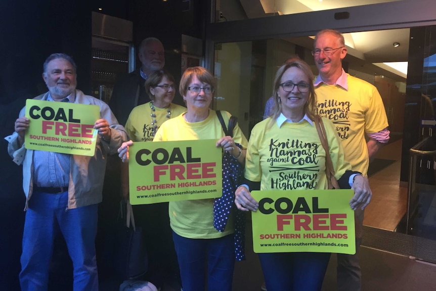 Six people gather outside court after hearing they won a challenge against Hume Coal.