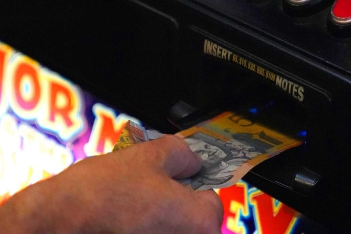 A 50 dollar note being inserted into a poker machine