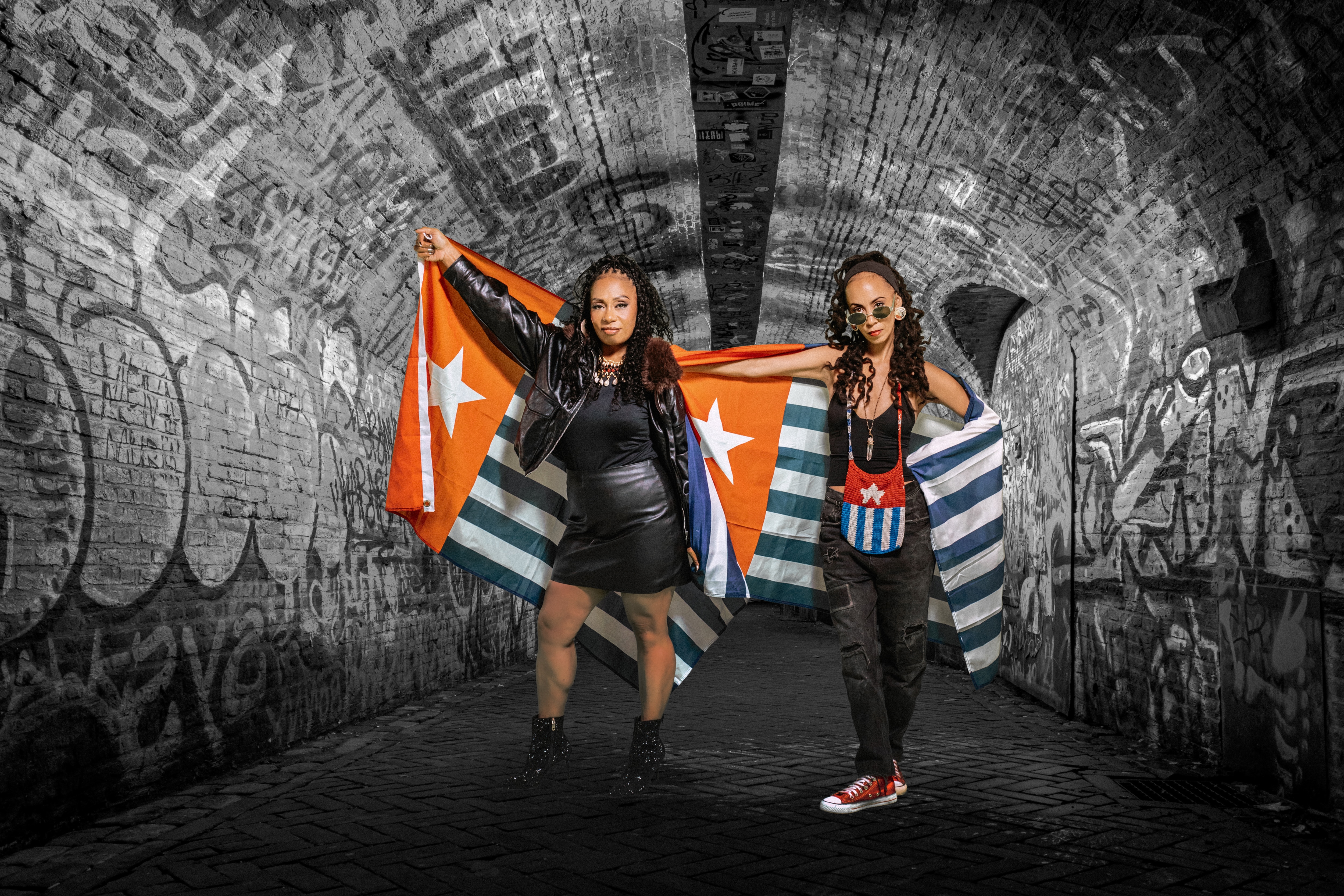 Lele and Nattali hold West Papuan flags in an underground tunnel