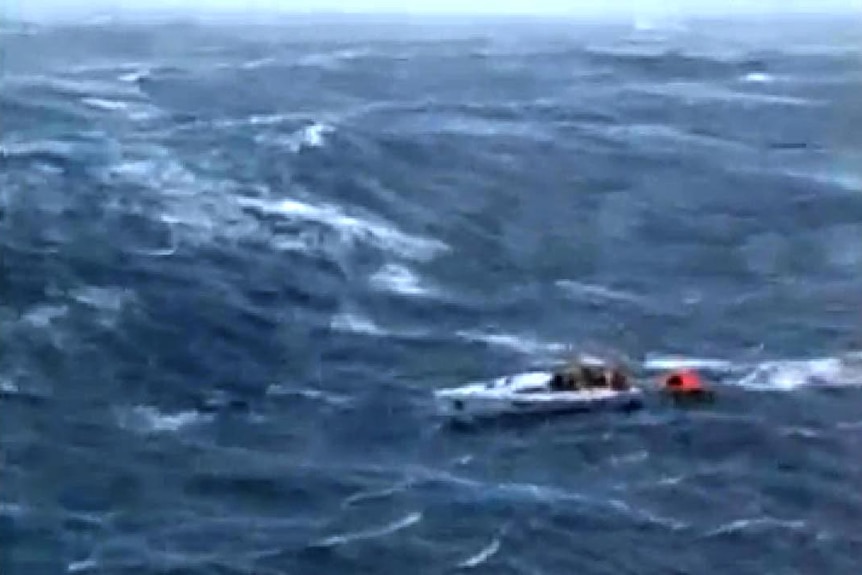 Aerial view of battered yacht tackling huge waves during the 1998 Sydney Hobart Yacht Race