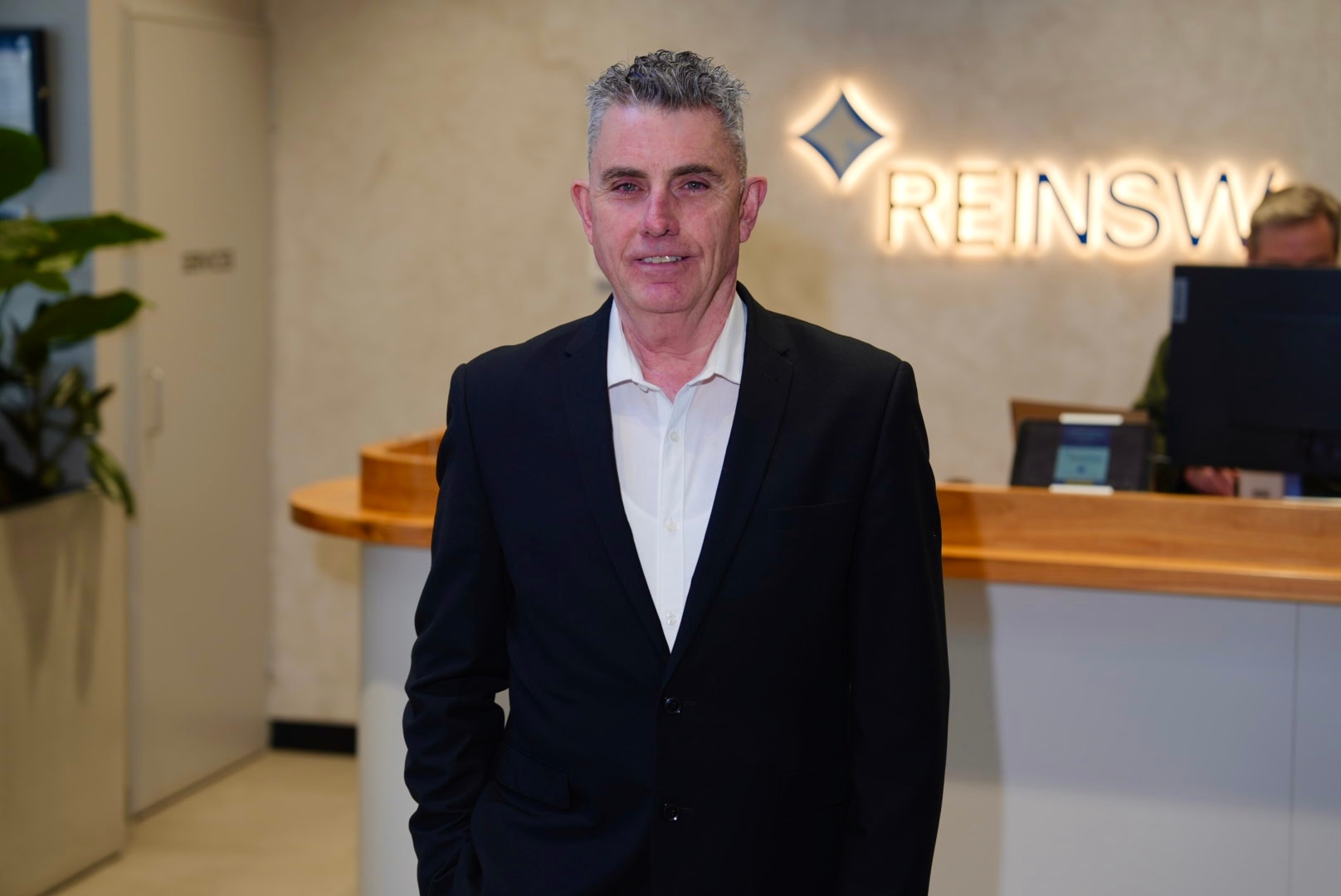 A man with grey hair wearing a suit and shirt
