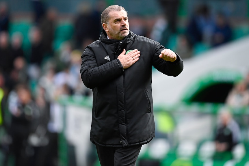 Ange Postecoglou taps the Celtic badge on his chest and clenches his left fist