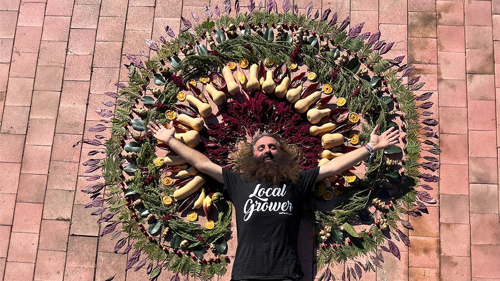 Costa lying in a circle of fruit surrounding him.