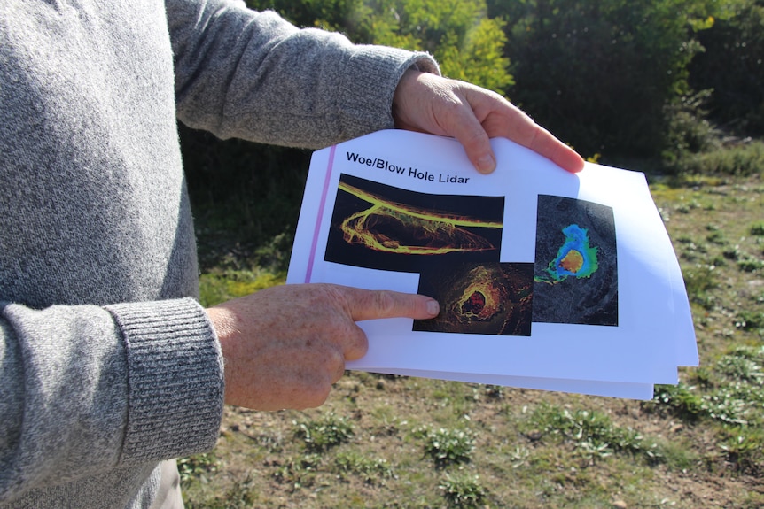 The hands of a man holding a pamphlet with 3D images