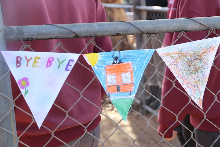 Coloured in flags hang on a fence