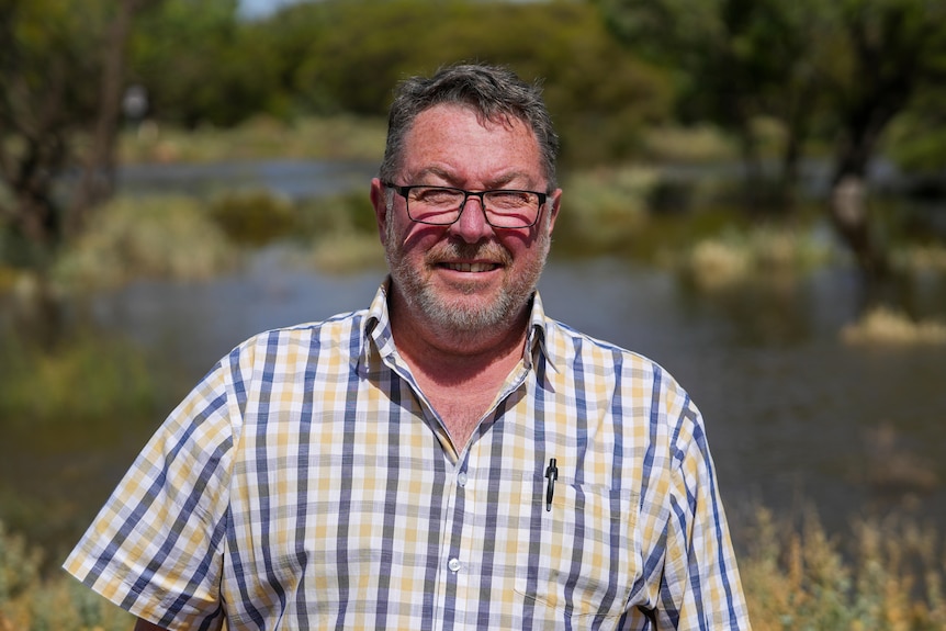 A man with a beard and glasses and a checked shirt