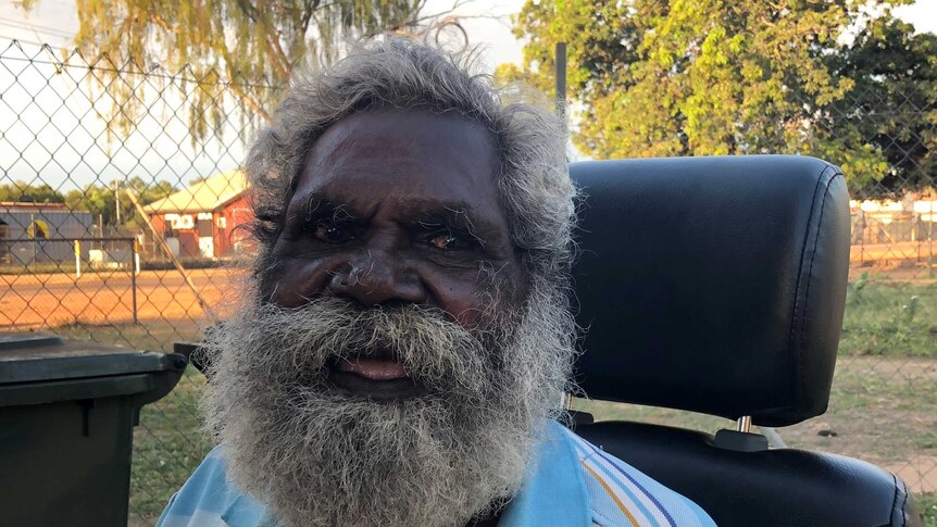 Indigneous Elder Peter Peenuggina sits in a chair.