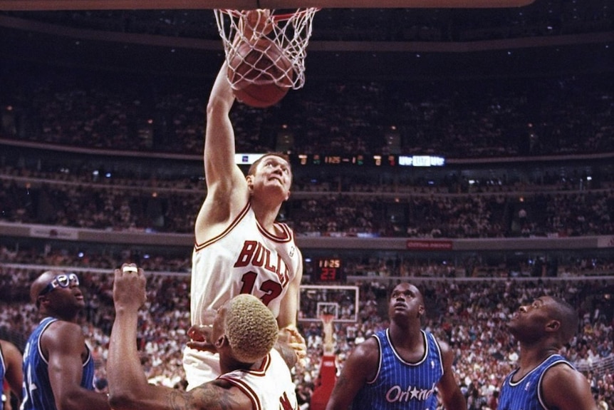 A man slam dunking a basketball.