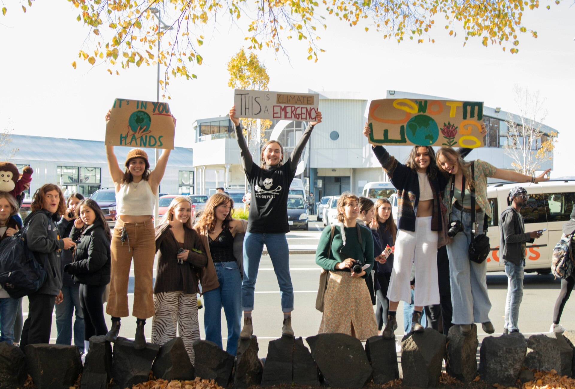A group of Hobart protesters standing and holding signs about climate change.