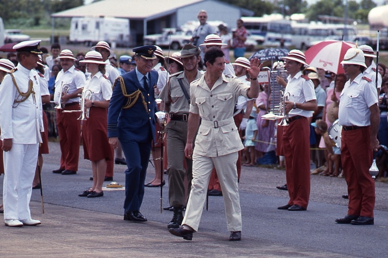 Prince Charles waves at onlookers while taking part in a parade in Darwin.