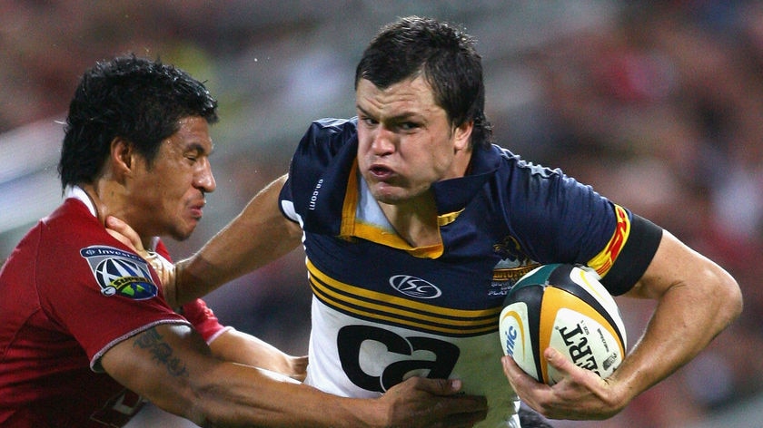 Adam Ashley-Cooper fends away from the Reds defence