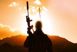 Silhouette of a soldier with a machine gun pointing to the sky.
