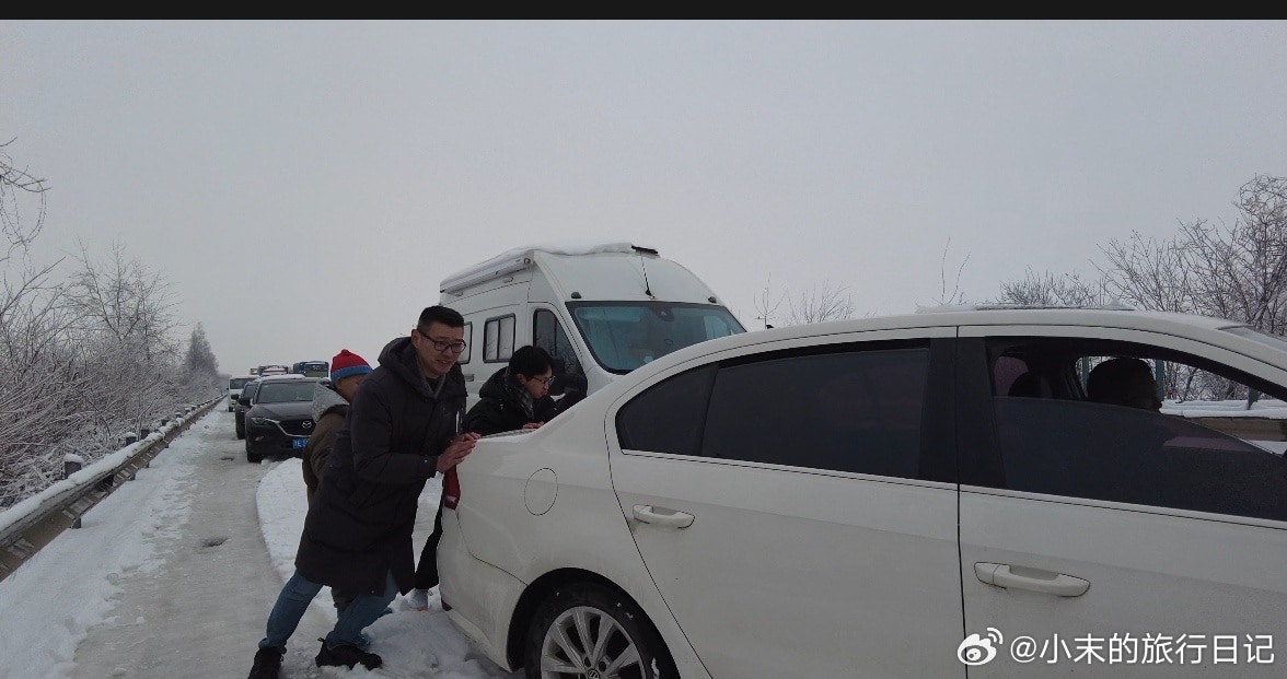 大雪路上人们在推车