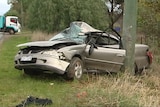 The wreckage of a car after it crashed into a pole.