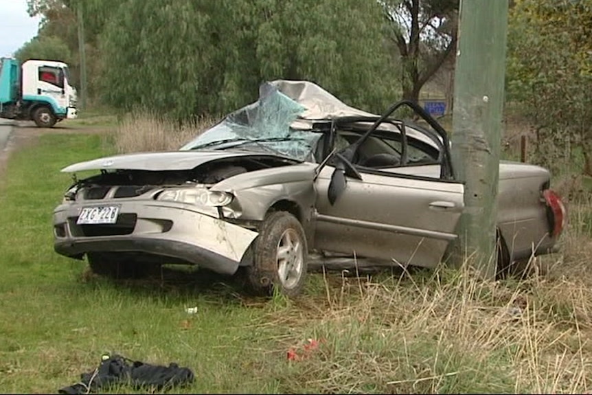 The wreckage of a car after it crashed into a pole.