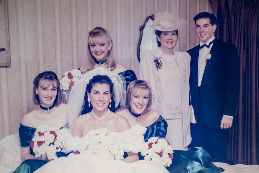 A bride and her bridesmaids pose with her parents