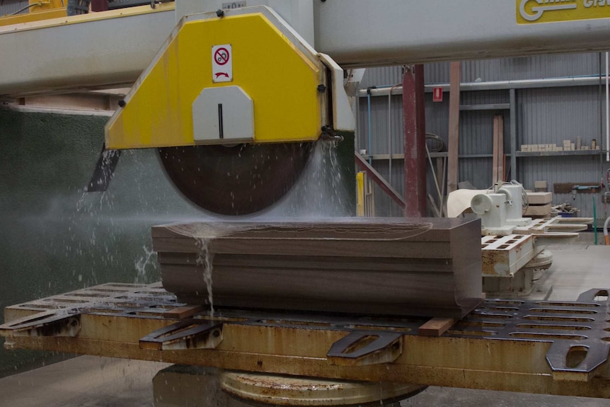 Machine saw cutting a large piece of sandstone