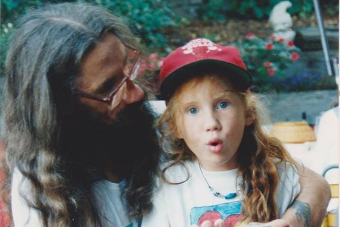 A man with a young girl with red hair in a cap