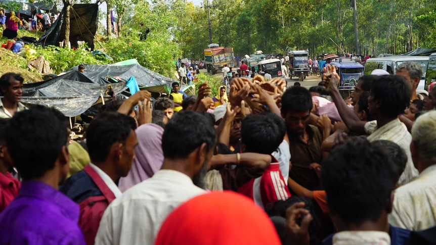 A group of people and traffic along a road in Kutupalong refugee camp in Bangladesh.