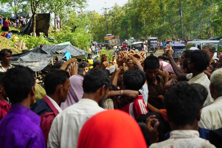 A group of people and traffic along a road in Kutupalong refugee camp in Bangladesh.