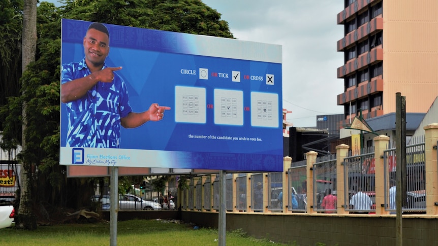 Blue billboard showing election information in Fiji. 