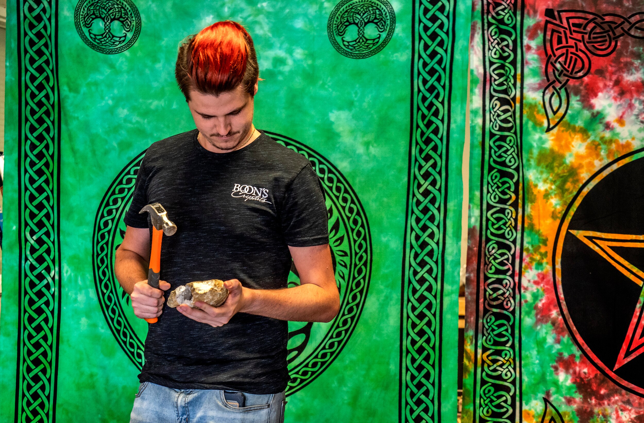 A man hitting a rock with a hammer.